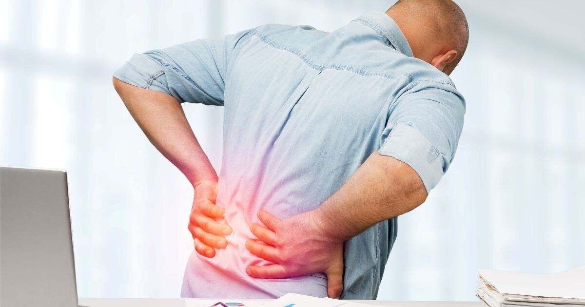 older man bent over holding back in pain 