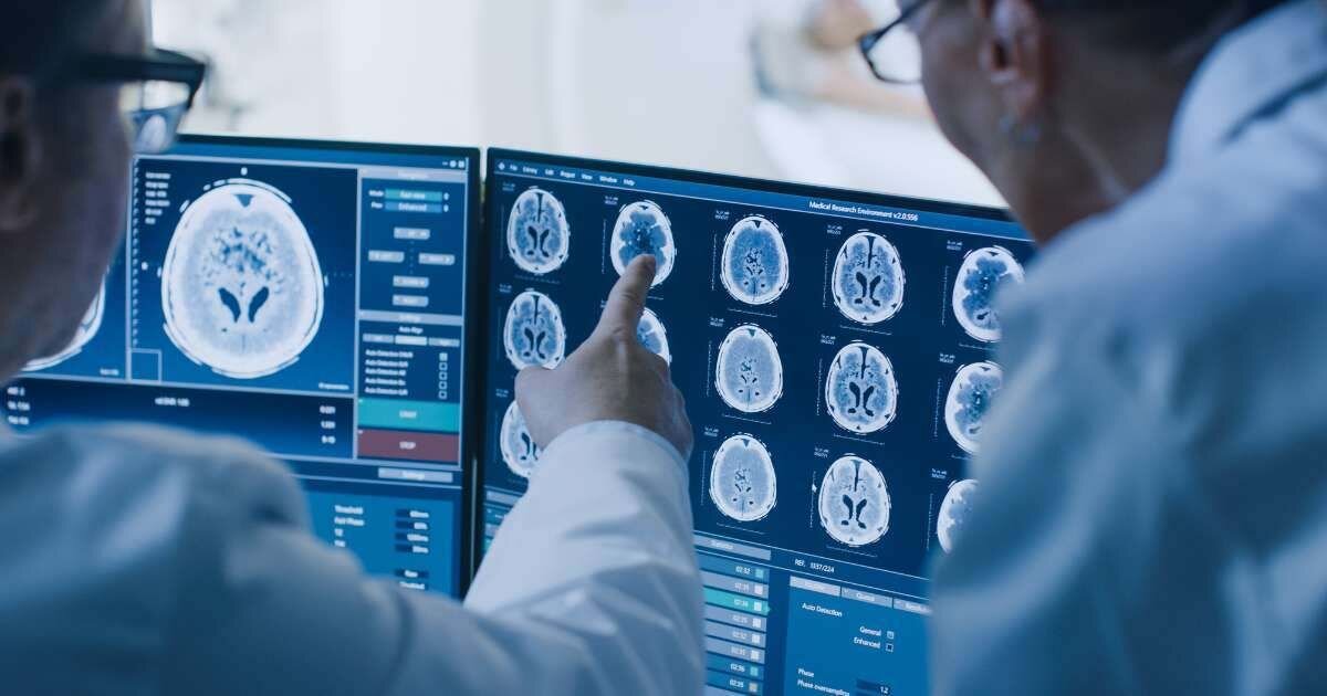 two radiologists viewing patient scans on computers